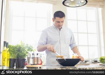 Middle-aged man preparing food in kitchen