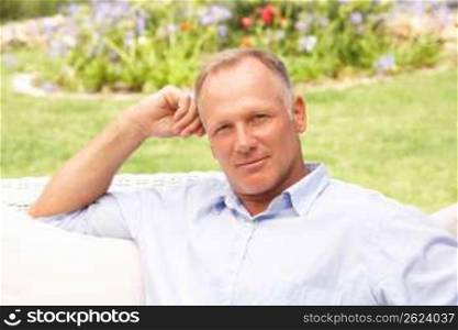 Middle Aged Man Relaxing In Garden