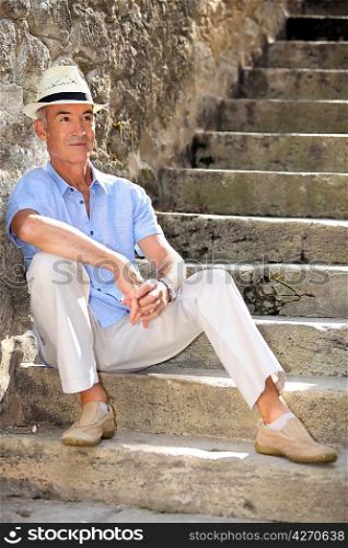 Middle-aged man sat on old stone steps