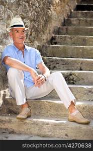 Middle-aged man sat on old stone steps