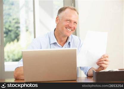 Middle Aged Man Using Laptop At Home