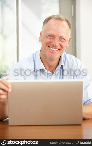 Middle Aged Man Using Laptop At Home