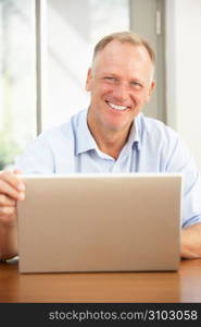 Middle Aged Man Using Laptop At Home