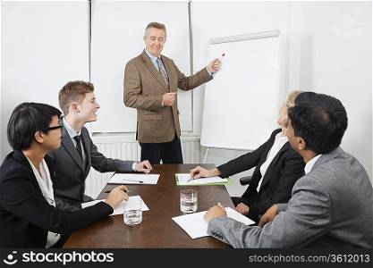 Middle-aged man using whiteboard in business meeting