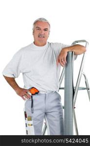 Middle-aged man with ladder and roll of wallpaper