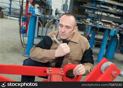middle-aged mechanic working with spanner