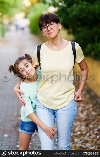 Middle-aged mother and daughter standing toghether on the street. Middle-aged mother and daughter standing on the street