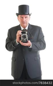Middle aged photographer in a retro business suit with retro camera isolated on white.