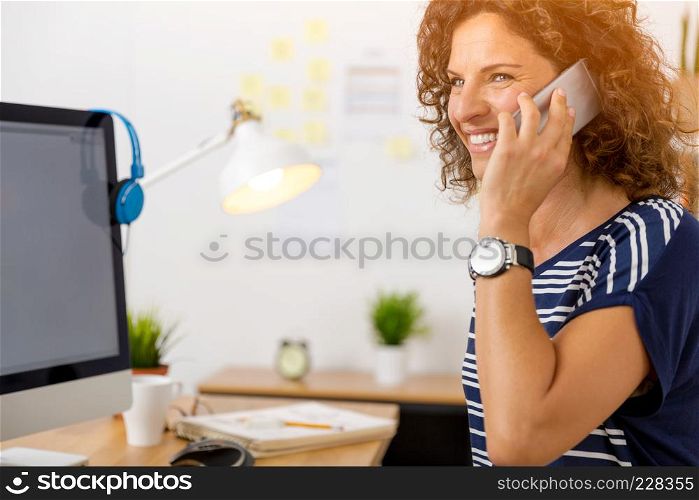 Middle aged woman at office making a phone call