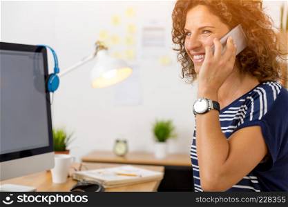 Middle aged woman at office making a phone call