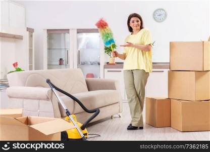 Middle-aged woman cleaning new apartment 