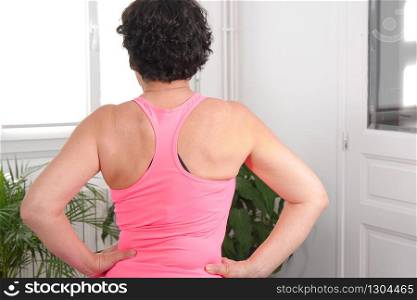Middle-aged woman doing fitness exercises, back view