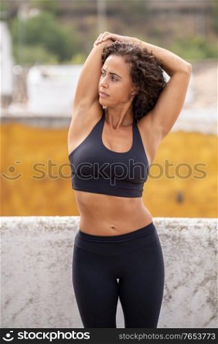 Middle-aged woman in her 40s with fitness body working out on the terrace of her house. Middle-aged woman with fitness body working out on the terrace of her house