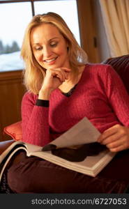 Middle Aged Woman Reading Magazine On Sofa