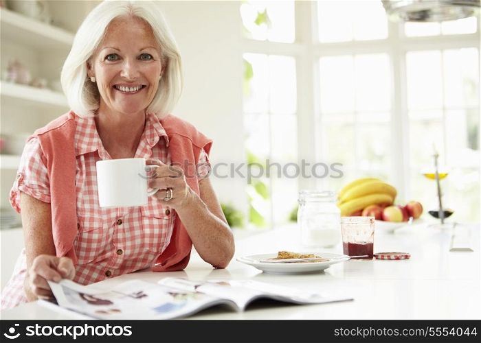 Middle Aged Woman Reading Magazine Over Breakfast