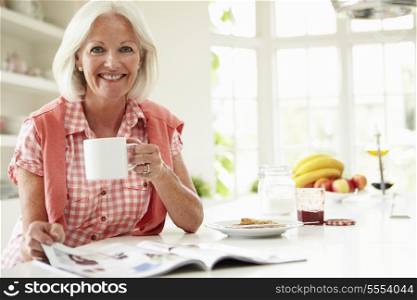 Middle Aged Woman Reading Magazine Over Breakfast