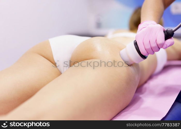 Middle-aged woman receiving anti-cellulite treatment with radiofrequency machine in an aesthetic clinic.. Woman receiving anti-cellulite treatment with radiofrequency machine in a beauty center.