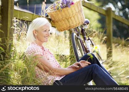 Middle Aged Woman Relaxing On Country Cycle Ride