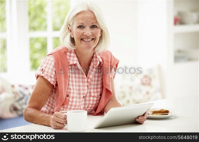 Middle Aged Woman Using Digital Tablet Over Breakfast