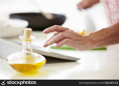Middle Aged Woman Using Recipe On Digital Tablet