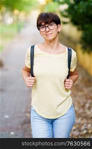Middle-aged woman walking in a city park in summer. Beautiful Middle-aged woman walking down the street