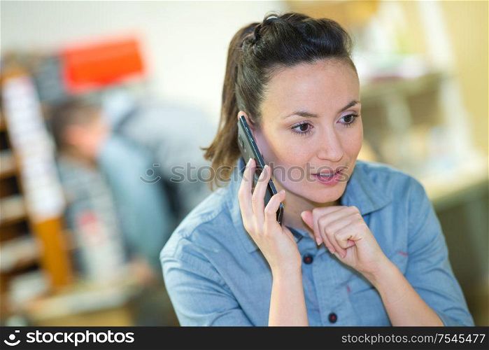 middle-aged woman wearing denim shirt using smartphone
