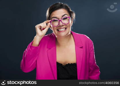 Middle aged woman with a funny face holding her own glasses