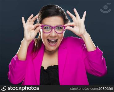 Middle aged woman with a funny face holding her own glasses