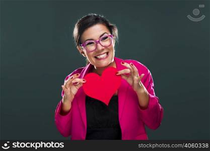 Middle aged woman with a happy face and holding a big red heart card