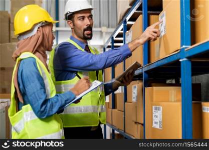 Middle east turkish white warehouse manager talk to Islam asian warehouse worker about inventory logistic route in distribution center. For business warehouse inventory and logistic concept.
