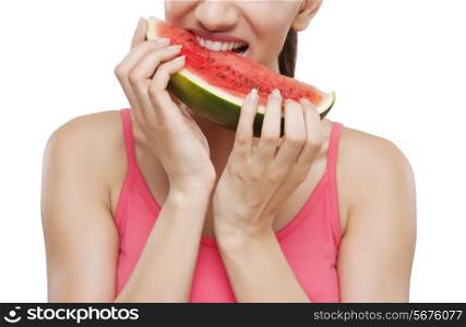 Midsection of a young woman biting watermelon over white background