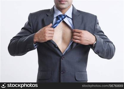 Midsection of businessman showing chest against gray background