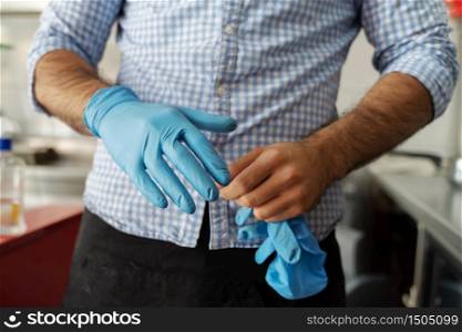 Midsection of caucasian man taking off or putting on protective gloves