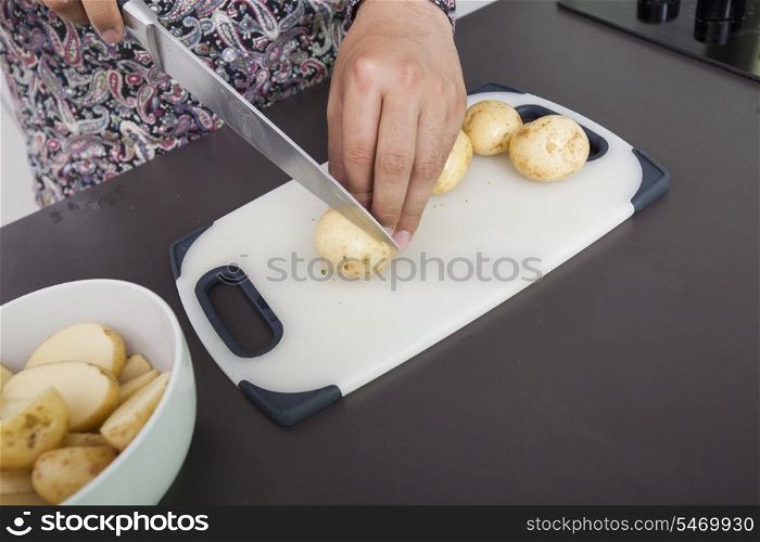 Midsection of man cutting potato at kitchen counter