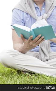 Midsection of man holding book in park