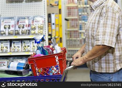 Midsection of man with shopping cart in hardware store