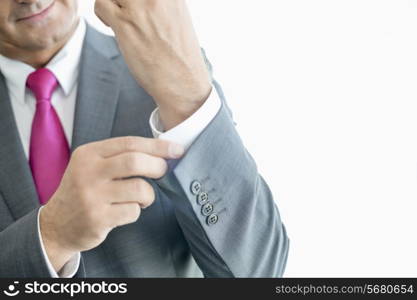 Midsection of mature businessman buttoning sleeve