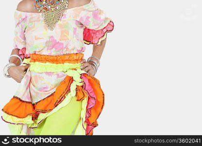 Midsection of senior woman in Brazilian costume over gray background