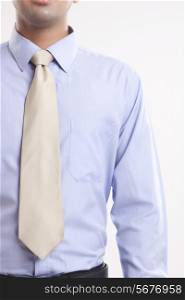 Midsection of young businessman in shirt and tie over white background