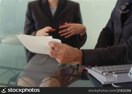 Midsection view of a businesswoman and a businessman in a meeting