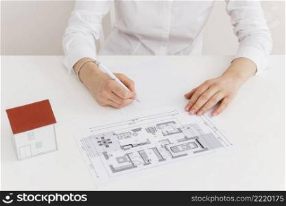 midsection woman working house blueprint desk office