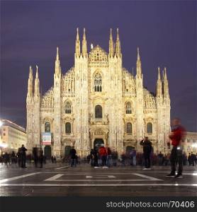 Milan Cathedral (Duomo di Milano) in Milan at night, Italy (people in motion blur)