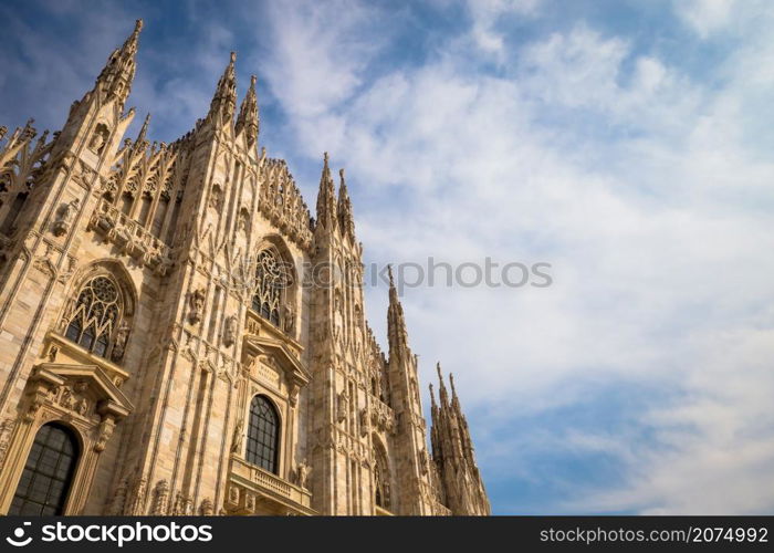 Milan Cathedral (Duomo di Milano) with copy space for text. Blue sky background and sunset light.