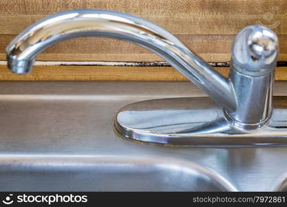 mildew or mold growth developing on a kitchen counter behind sink and faucet