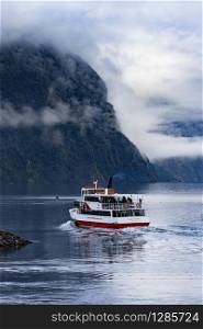 MILFORD SOUND NEW ZEALAND - AUGUST 30,2015 : tourist boat cruising in harbor of milford sound most popular natural traveling destination in southland new zealand