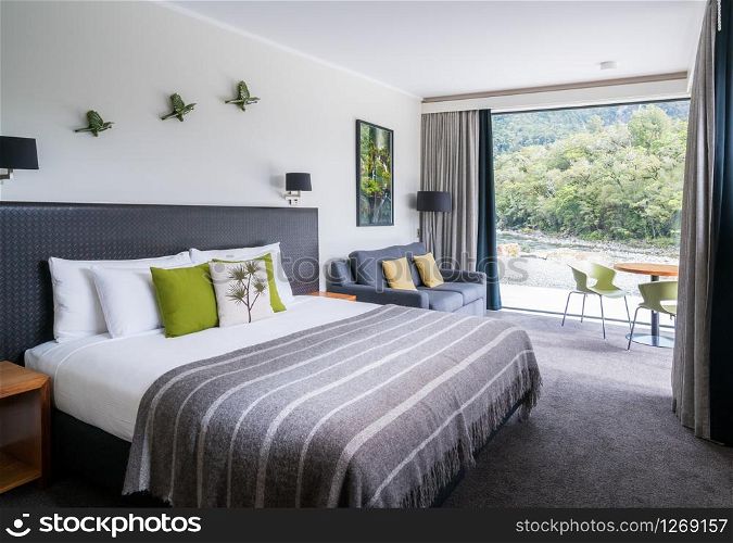 Milford Sound, New Zealand - Dec 7, 2016: Luxury bedroom interior decoration with nature scenic window look out at Milford Sound Lodge, accommodation in Milford Sound, Fiordland, New Zealand.
