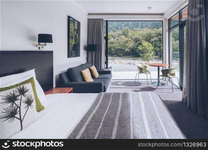Milford Sound, New Zealand - Dec 7, 2016: Luxury bedroom interior decoration with nature scenic window look out at Milford Sound Lodge, accommodation in Milford Sound, Fiordland, New Zealand.