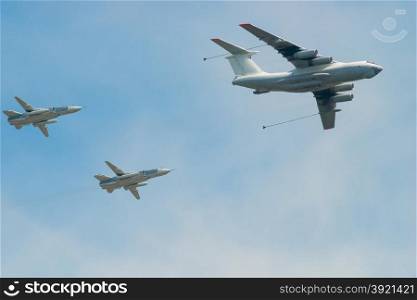 military aircraft with fuel and two fighters in the sky to refuel