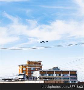 military fighter aircrafts flight in blue sky over urban house