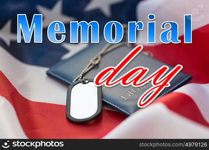 military forces, patriotism and national holidays concept - memorial day words over american flag, passport and soldiers badges. memorial day words on american flag and dog tags